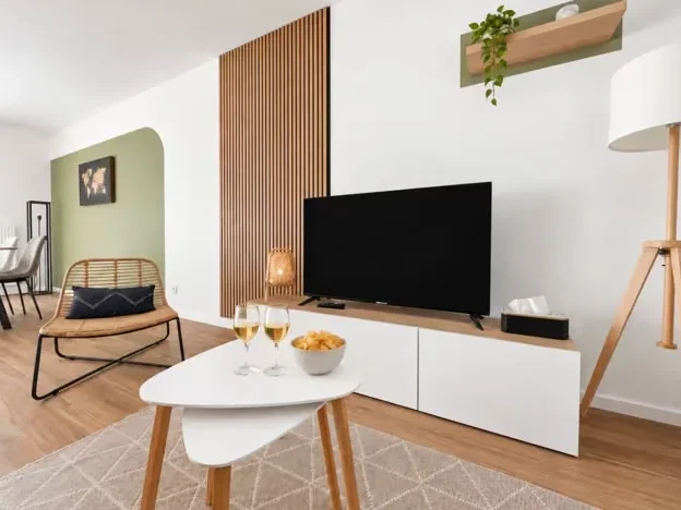 Salon avec meuble TV en bois et fauteuil en rotin